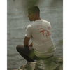 Guy wearing a Tan t-shirt with Eem restaurant logo and lion design on the back