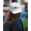 Girl wearing a White baseball hat with Marco's bar logo and pink rose on the front